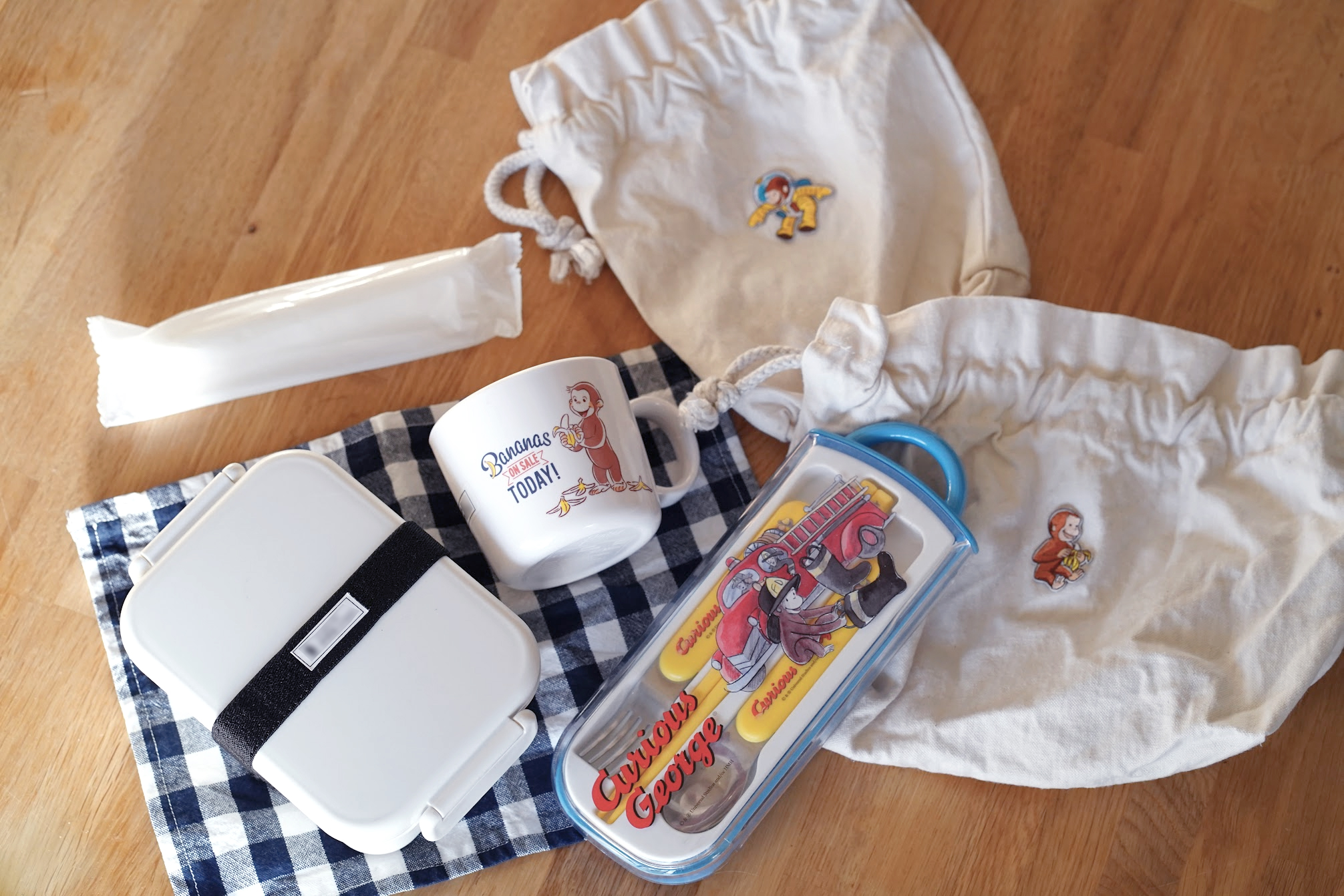 帆布の巾着にワッペンをつけた、おさるのジョージのシンプルなお弁当セット